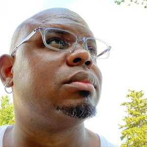 Profile picture of Caanan White. A close up of the artist's profile as he looks off into the distance.
